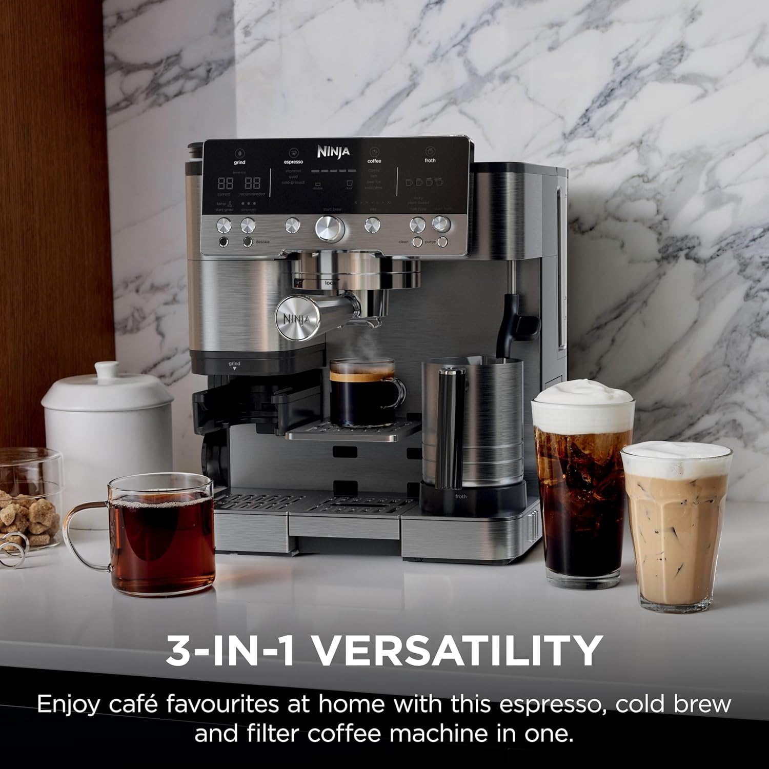 Ninja 3-in-1 espresso, cold brew, and filter coffee machine on a marble countertop with various cafe drinks.